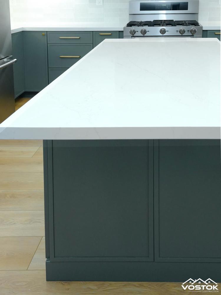 A kitchen with a large island and a stove top oven