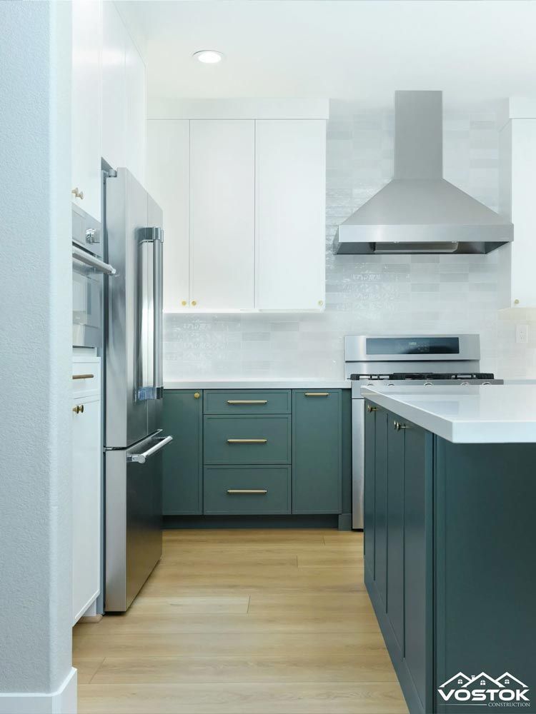 A kitchen with green cabinets and stainless steel appliances