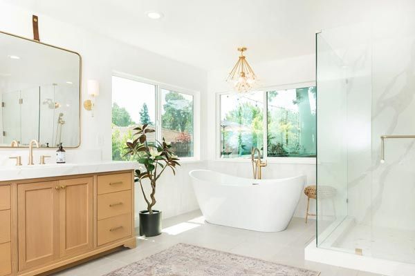 A bathroom with a tub , sink , mirror and walk in shower.