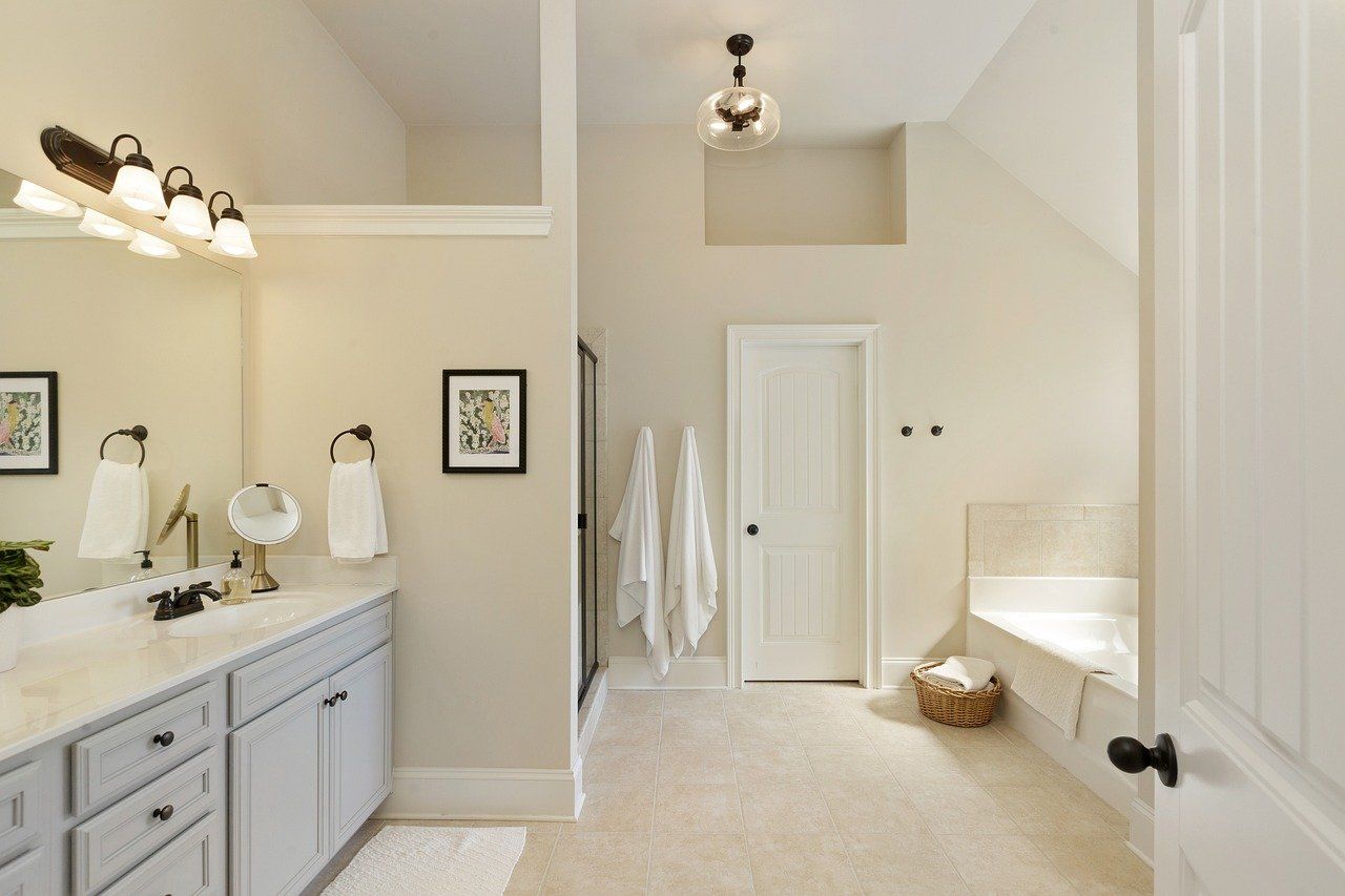 Modern bathroom with double vanity, glass shower, built-in tub, and soft neutral tones.
