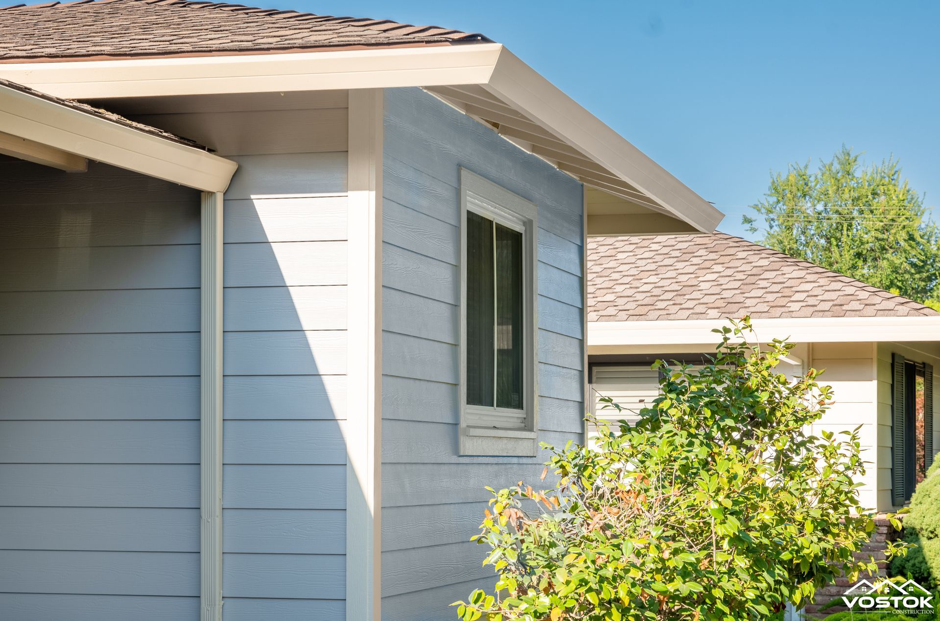 A white house with a brown roof and a window