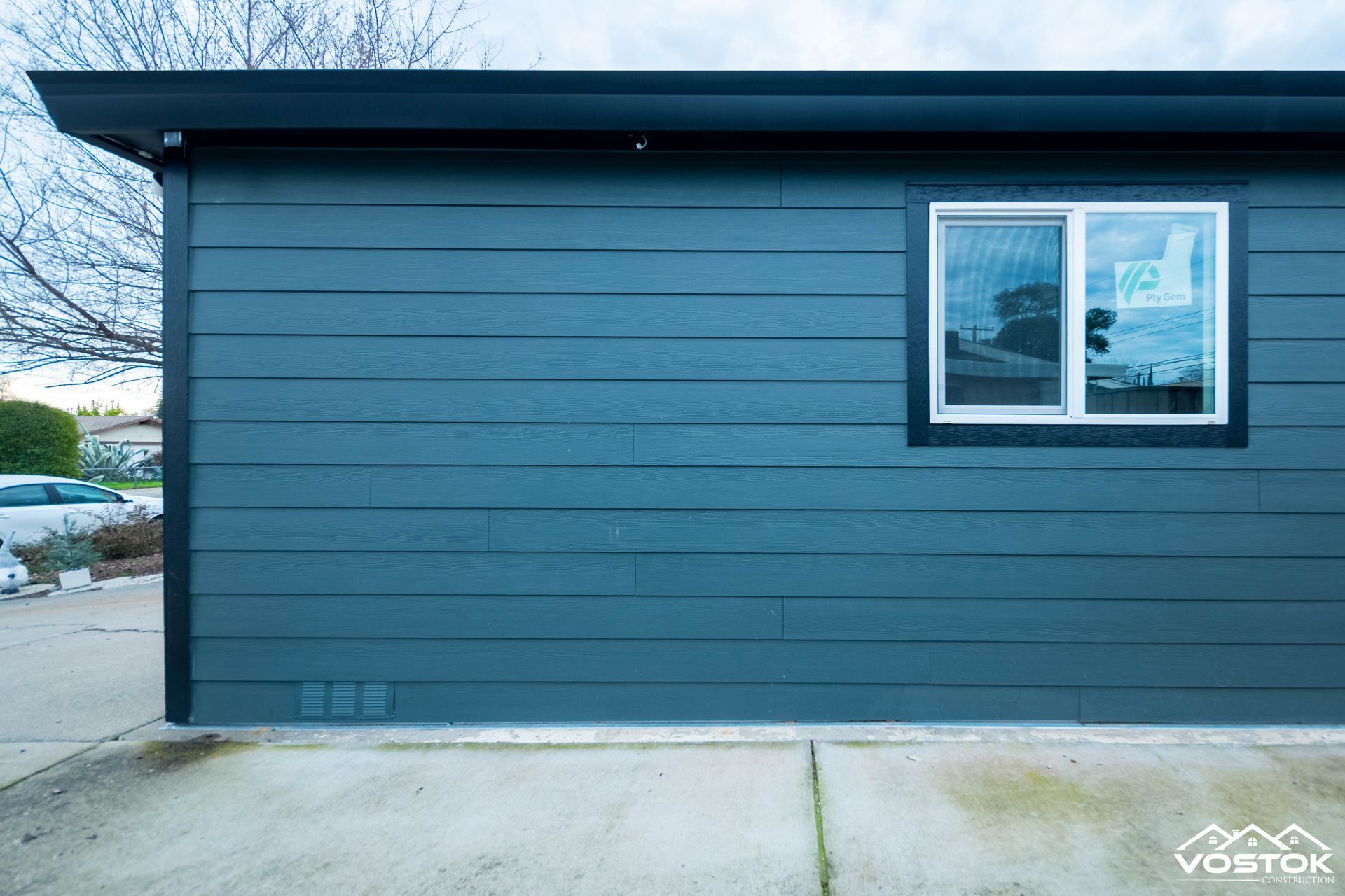 A blue house with a window on the side of it.