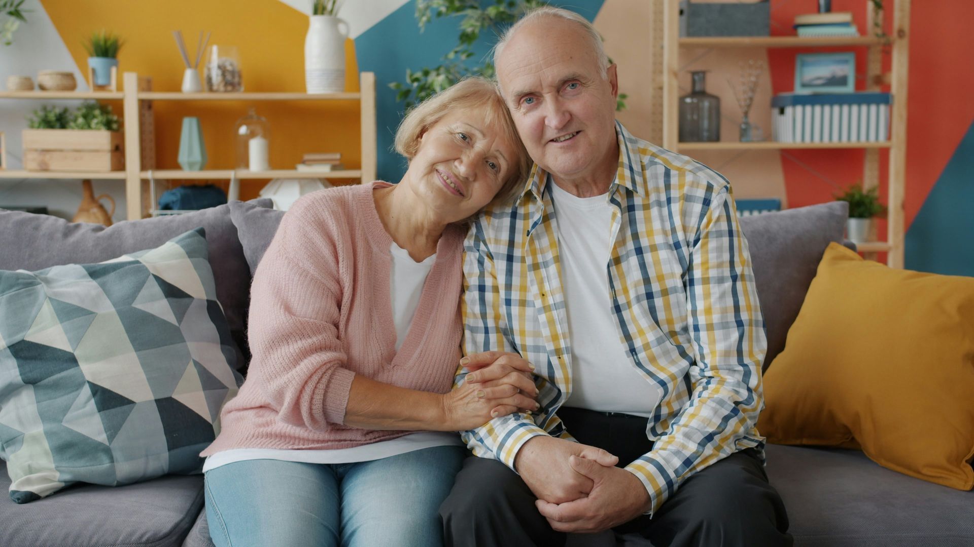 Older couple relaxes together in a cozy, colorful home designed for aging in place comfort.