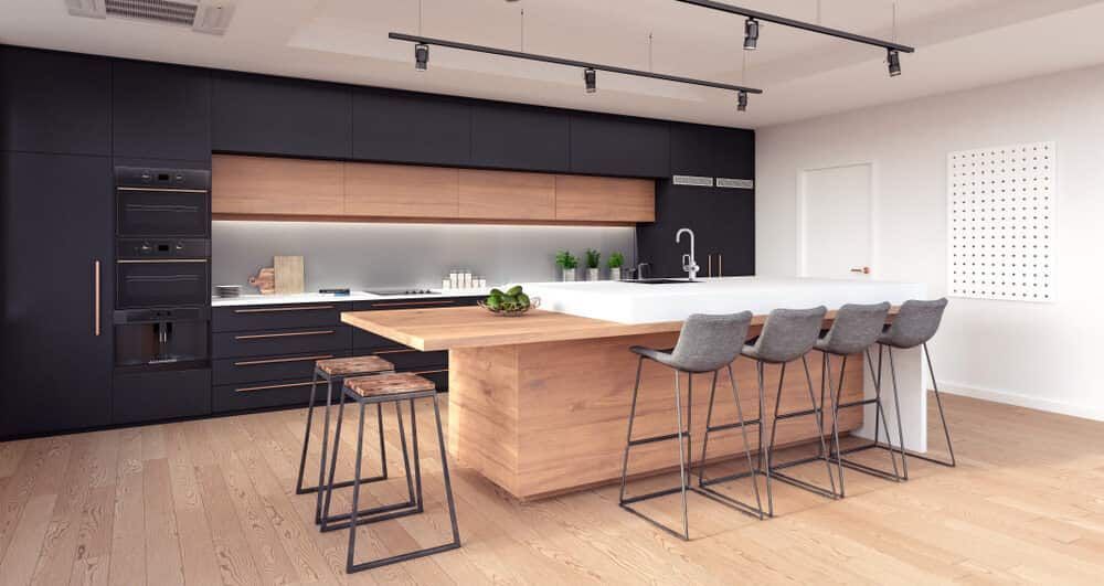 A kitchen with black cabinets, a wooden island, and stools — South East Kitchens In Burleigh Heads, QLD