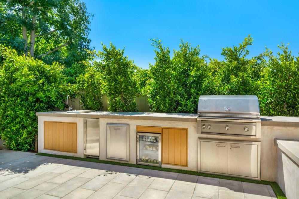 An Outdoor Kitchen With A Stainless-Steel Grill, Sink, And Cabinet Storage — South East Kitchens In Burleigh Heads, QLD