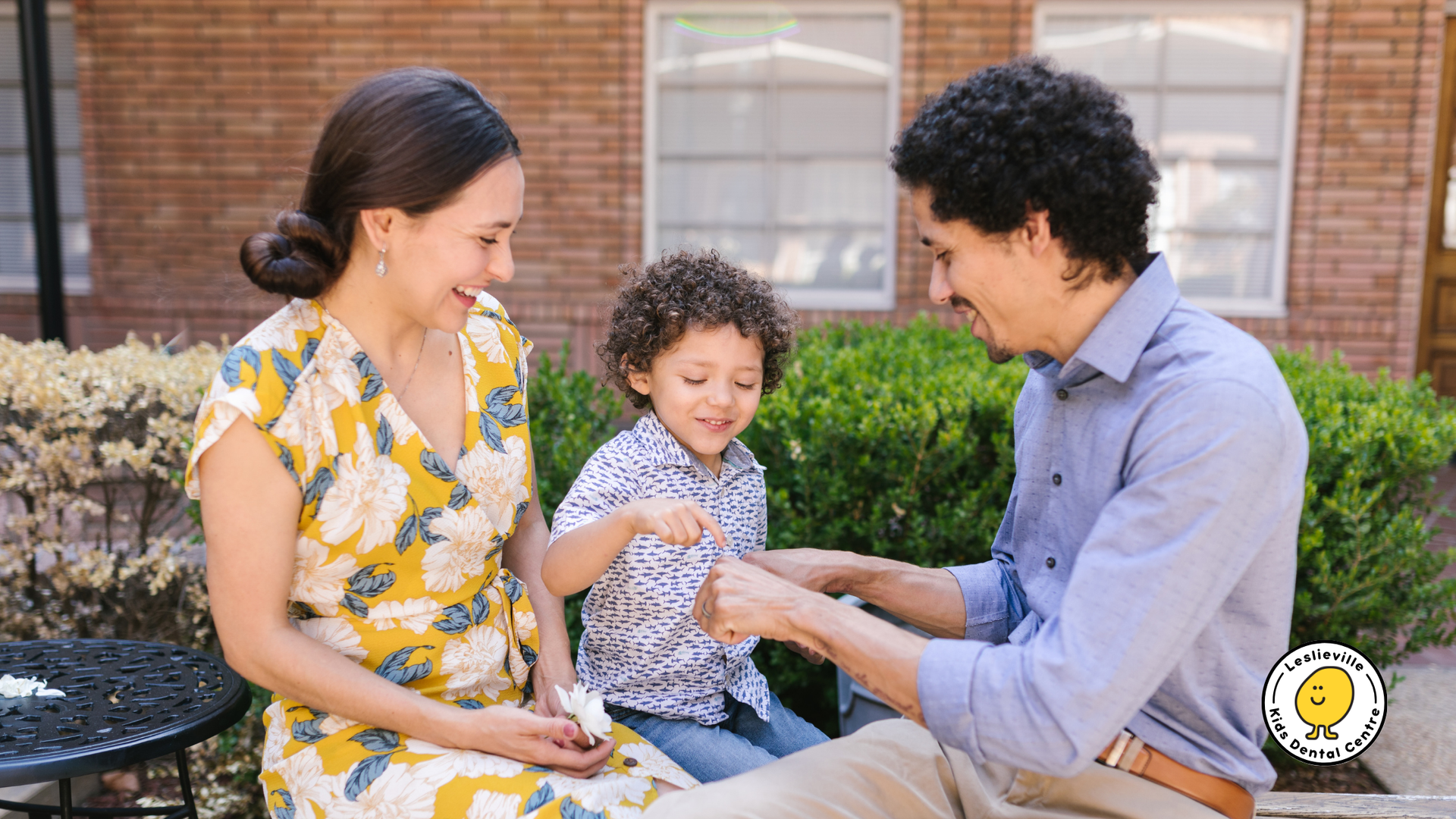 A man and woman are sitting on a bench with a child.