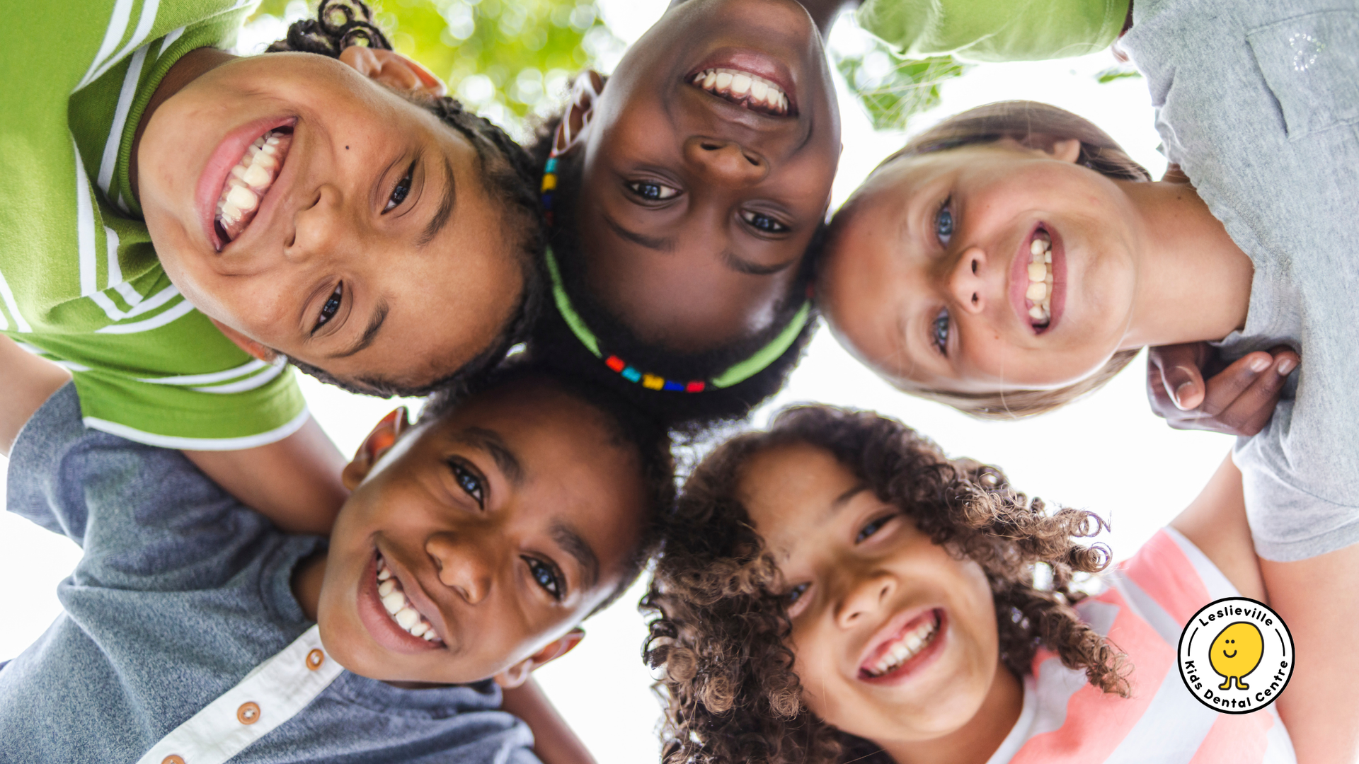 A group of children are standing in a circle and smiling.