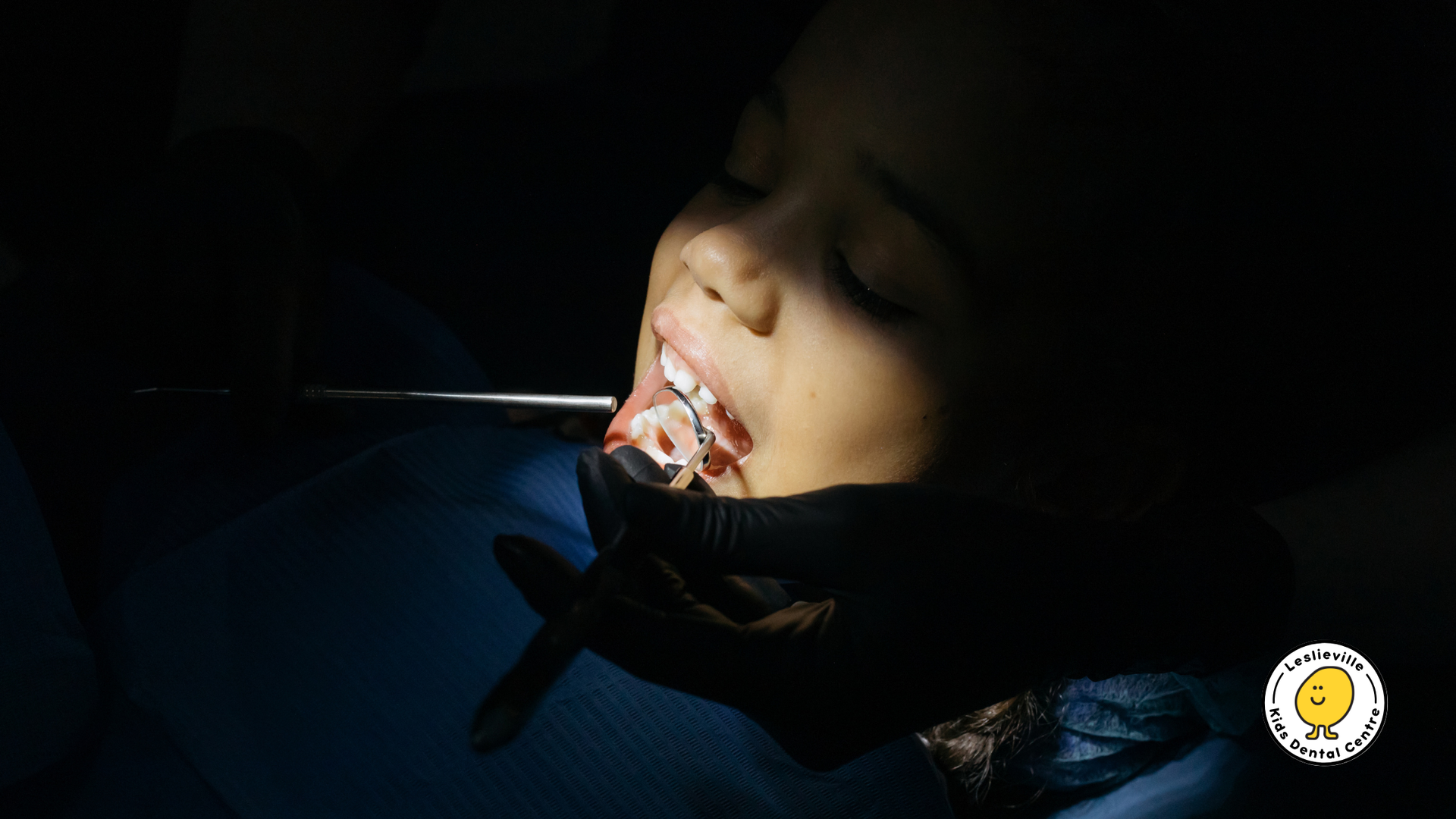 A woman with braces on her teeth is getting her teeth examined by a dentist.