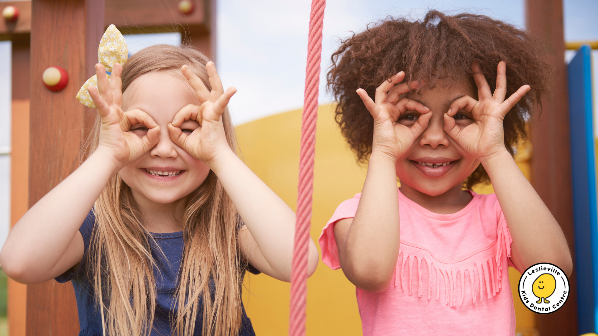 Two girls with blonde and curly brown hair making circle 