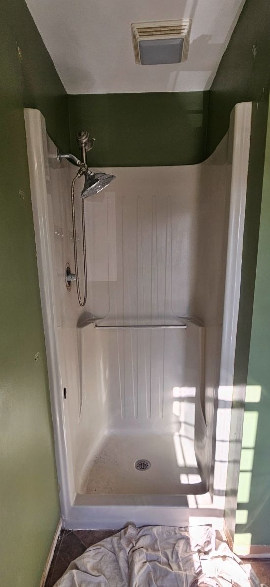 A bathroom with a bathtub and a shower stall.