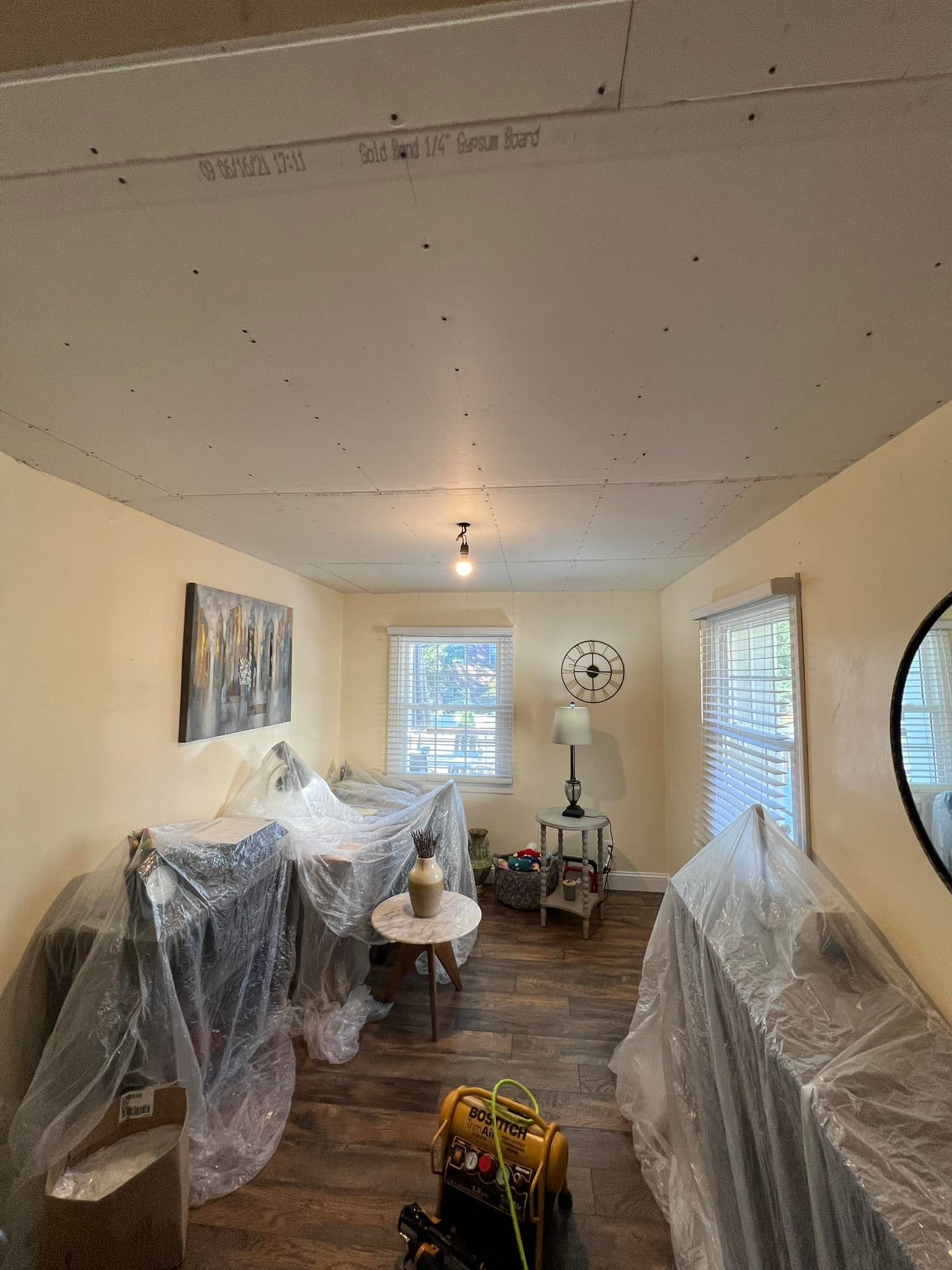 A living room is being remodeled and covered in plastic — Pequannock Township, NJ — Alb Premium Painting