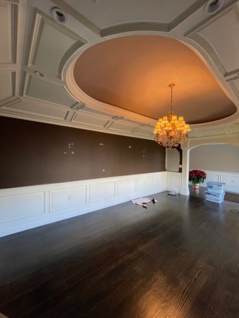 An empty room with a chandelier hanging from the ceiling