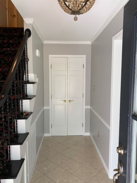 A hallway with a black door and stairs