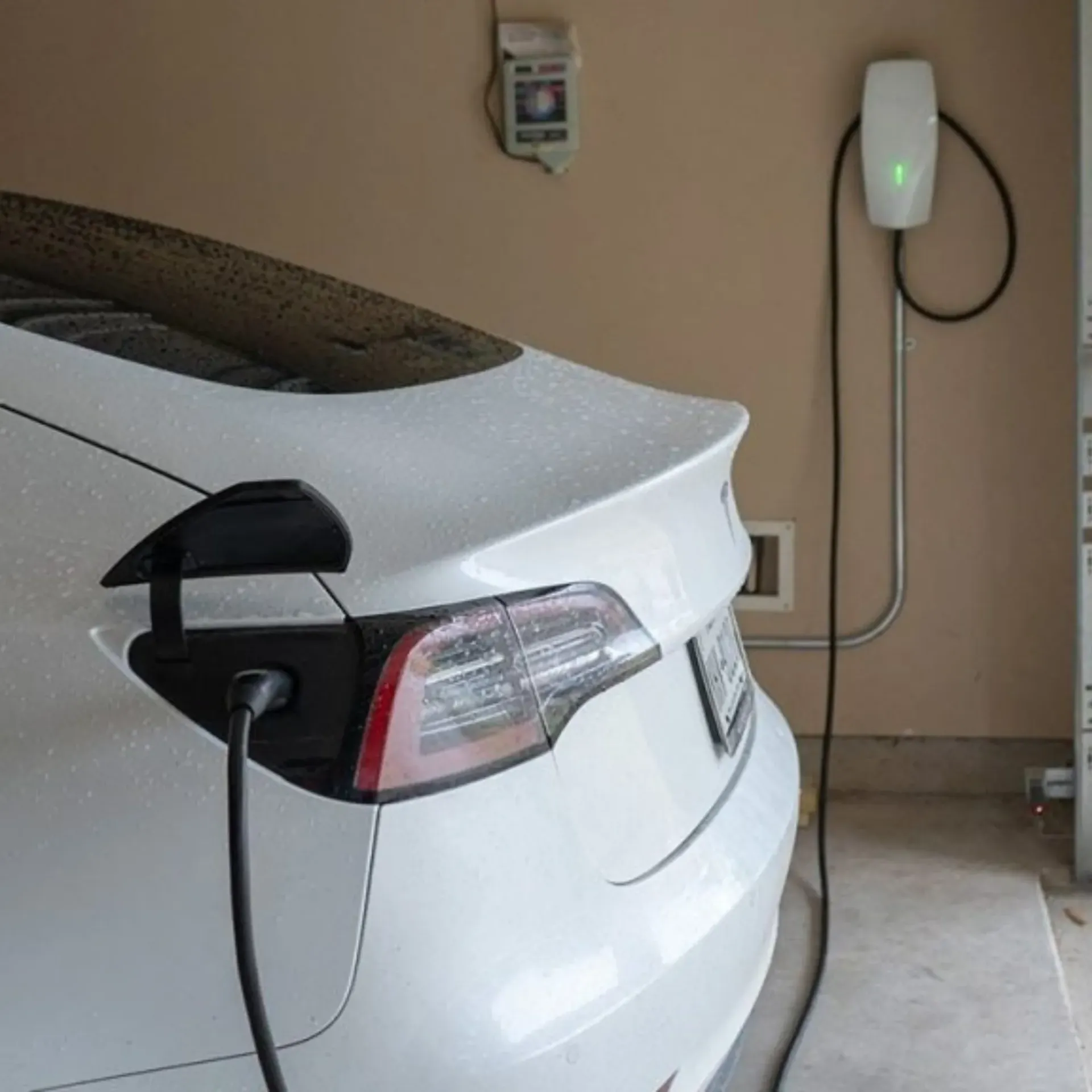 Horizon Electric USA - A white electric car is being charged in a garage.