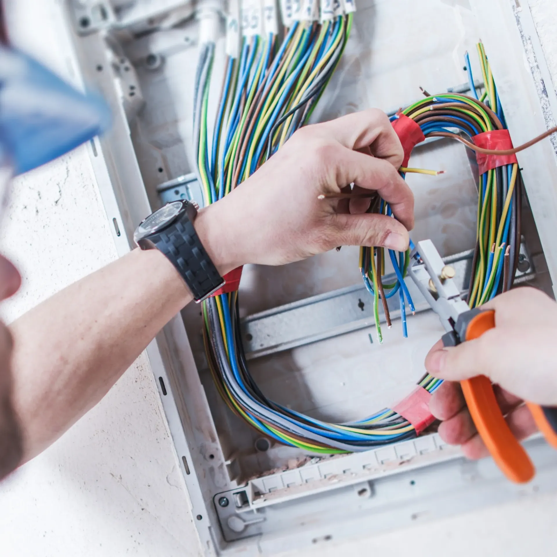 Horizon Electric USA - A man is working on an electrical box with a pair of pliers.