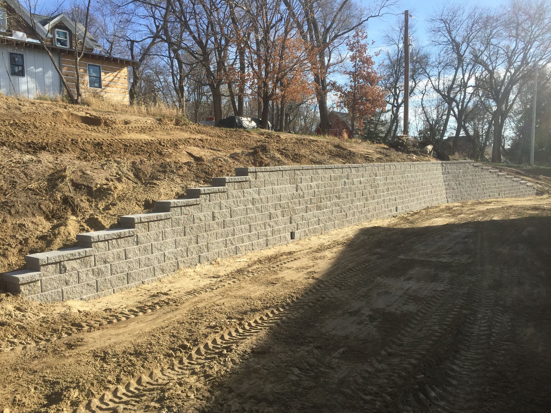 A brick wall is being built on top of a dirt hill.
