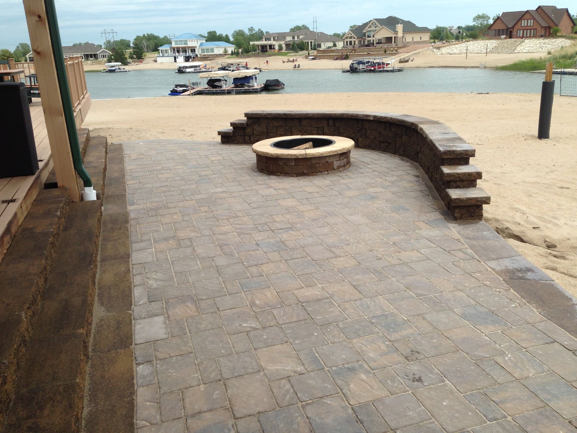 A fire pit on a patio next to a body of water