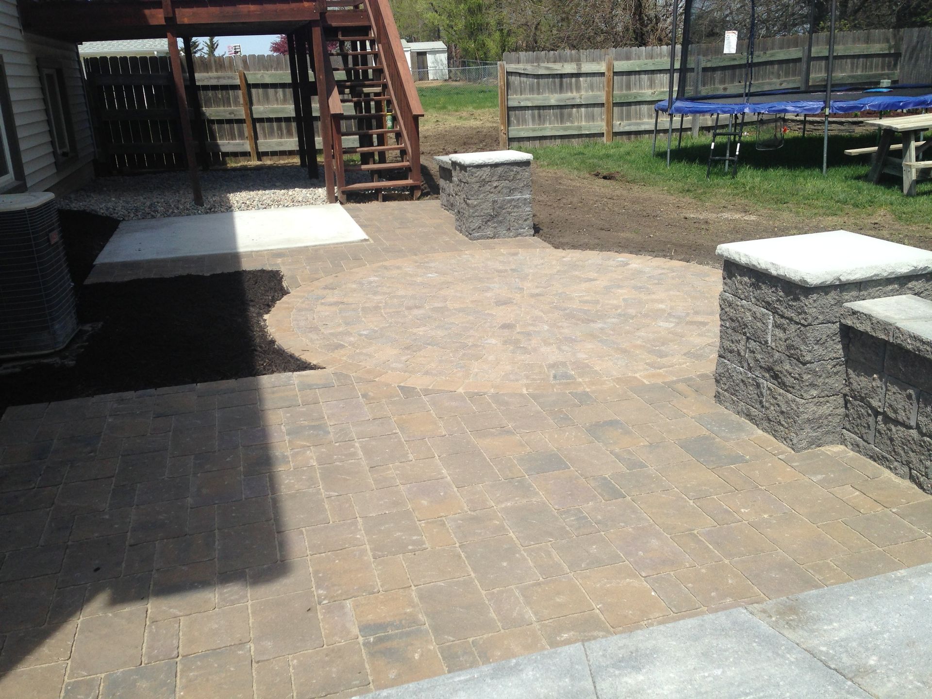 A patio with a trampoline in the backyard