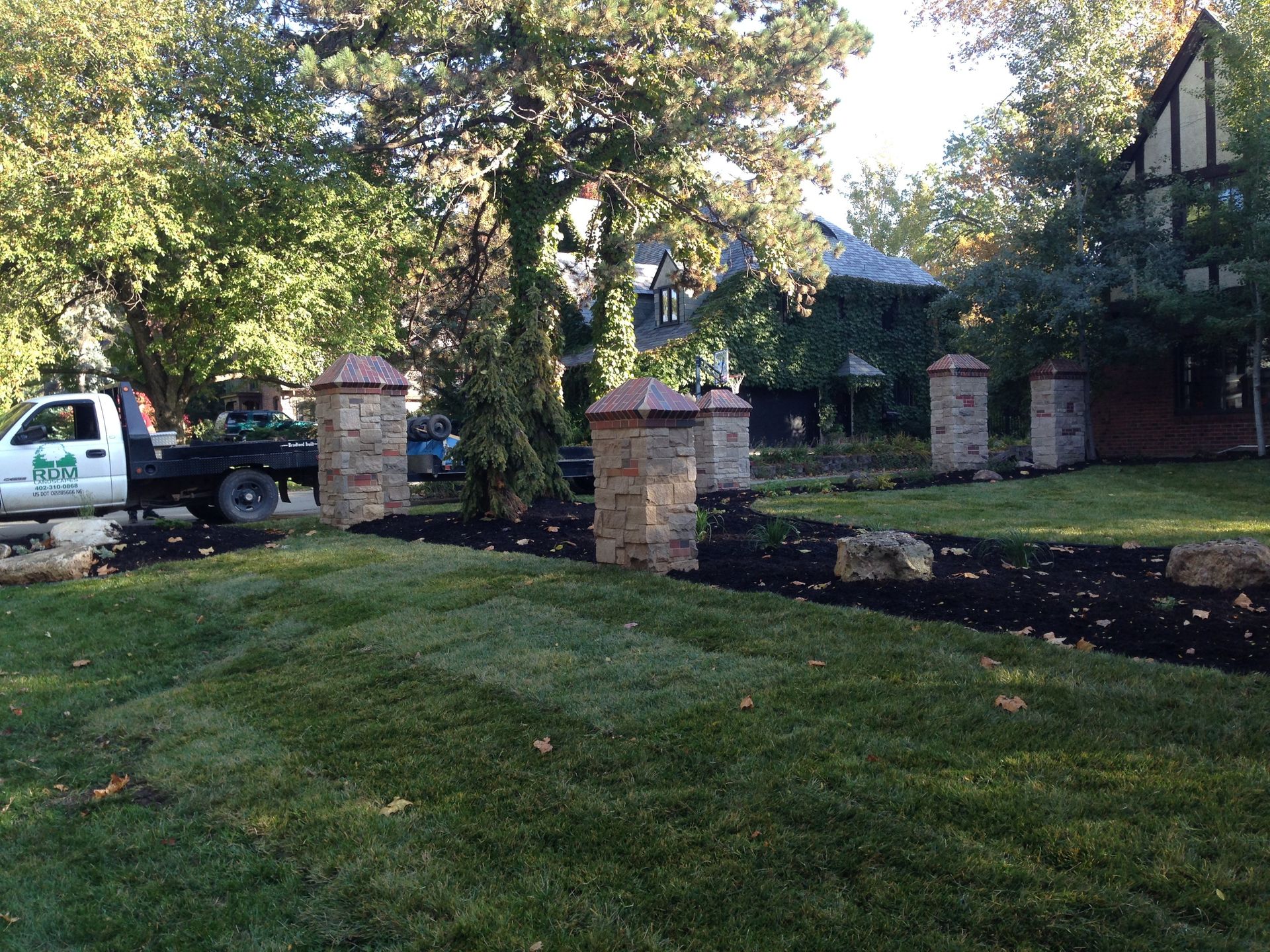 A white truck is parked in front of a large house.