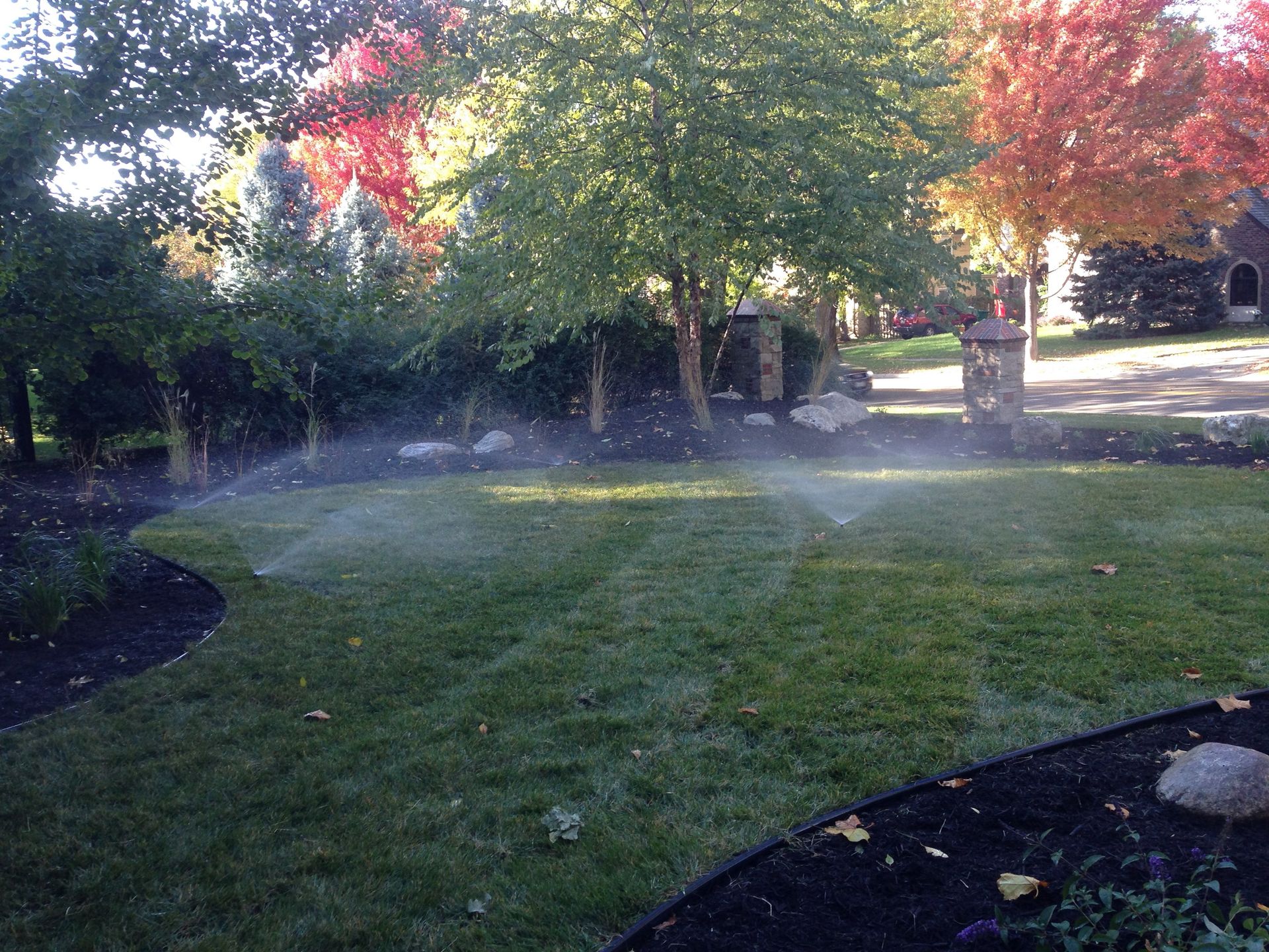 A sprinkler is spraying water on a lush green lawn