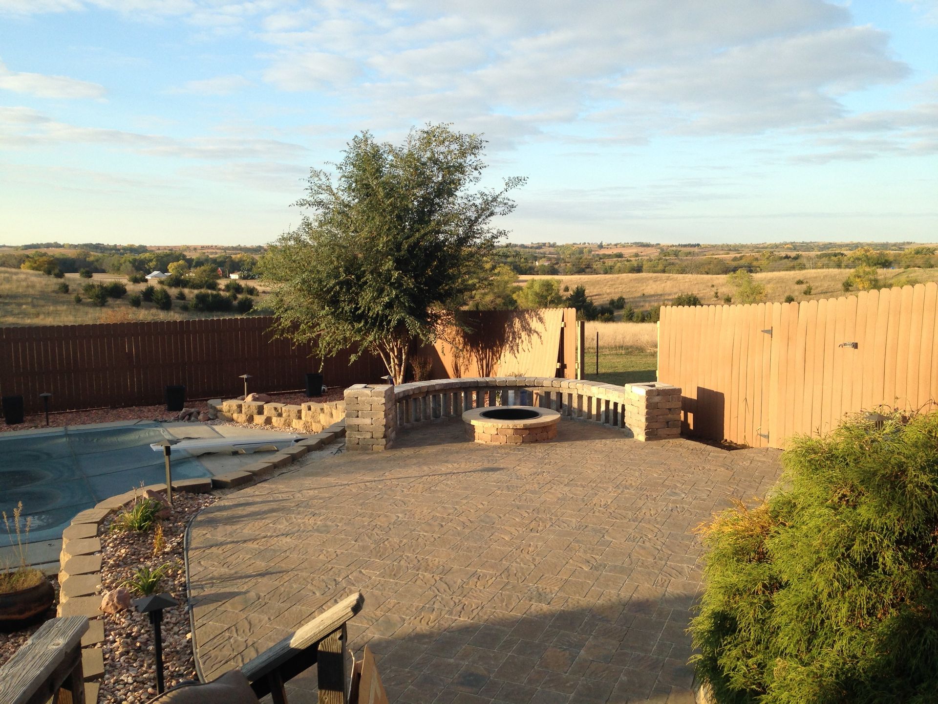 A backyard with a pool and a fire pit