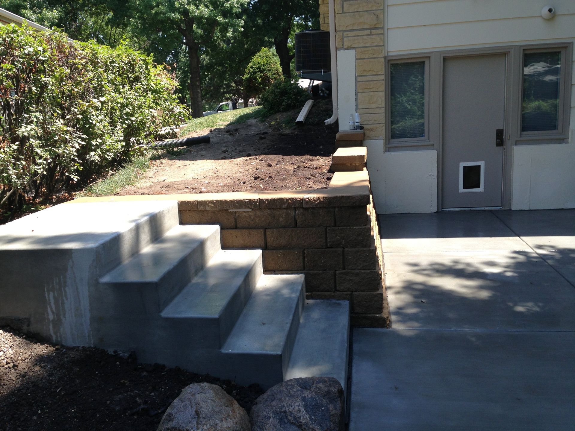 Stairs leading up to a house with a dog door