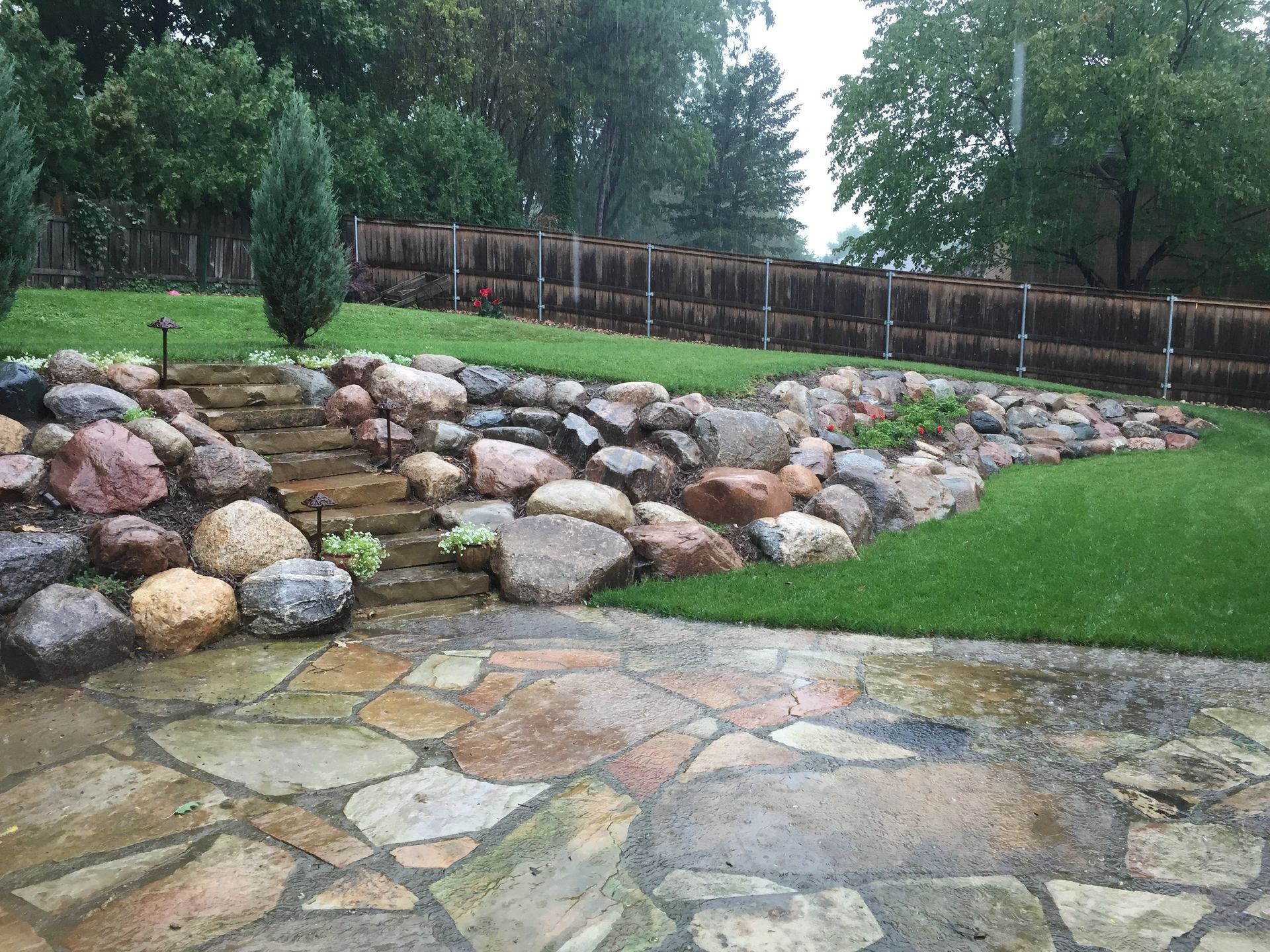 A stone patio with a fence in the background