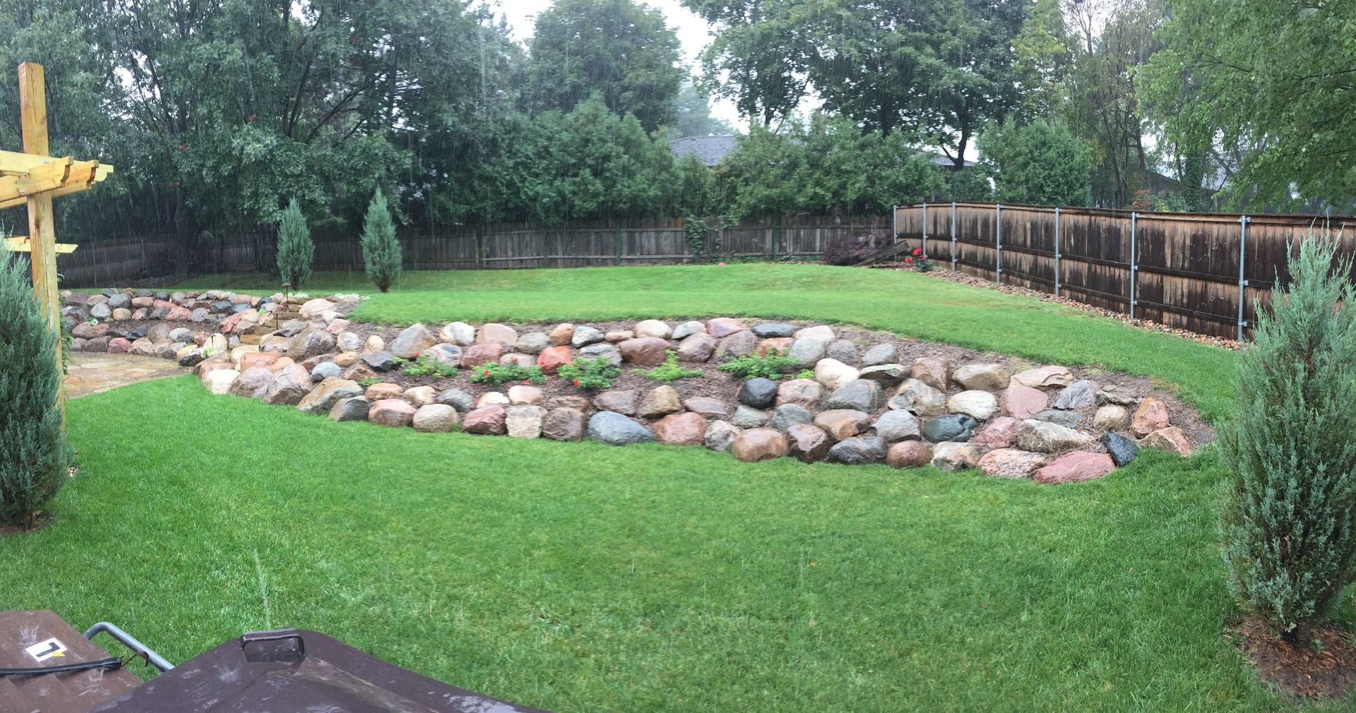 A lush green lawn with a stone wall in the middle of it.