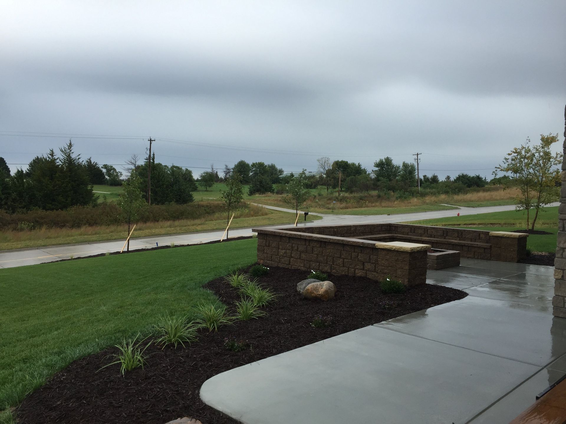 A patio with a fire pit and a walkway in the background
