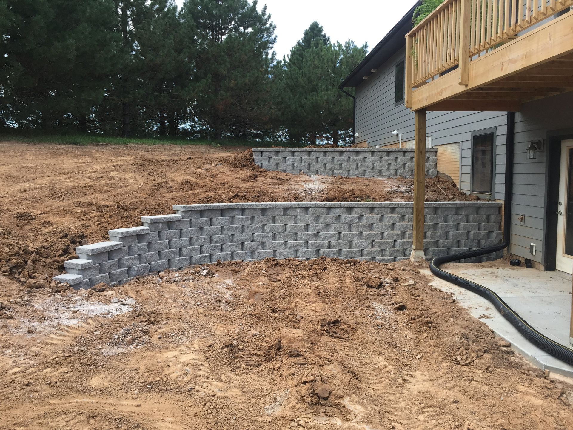 A house with a deck and a retaining wall in front of it