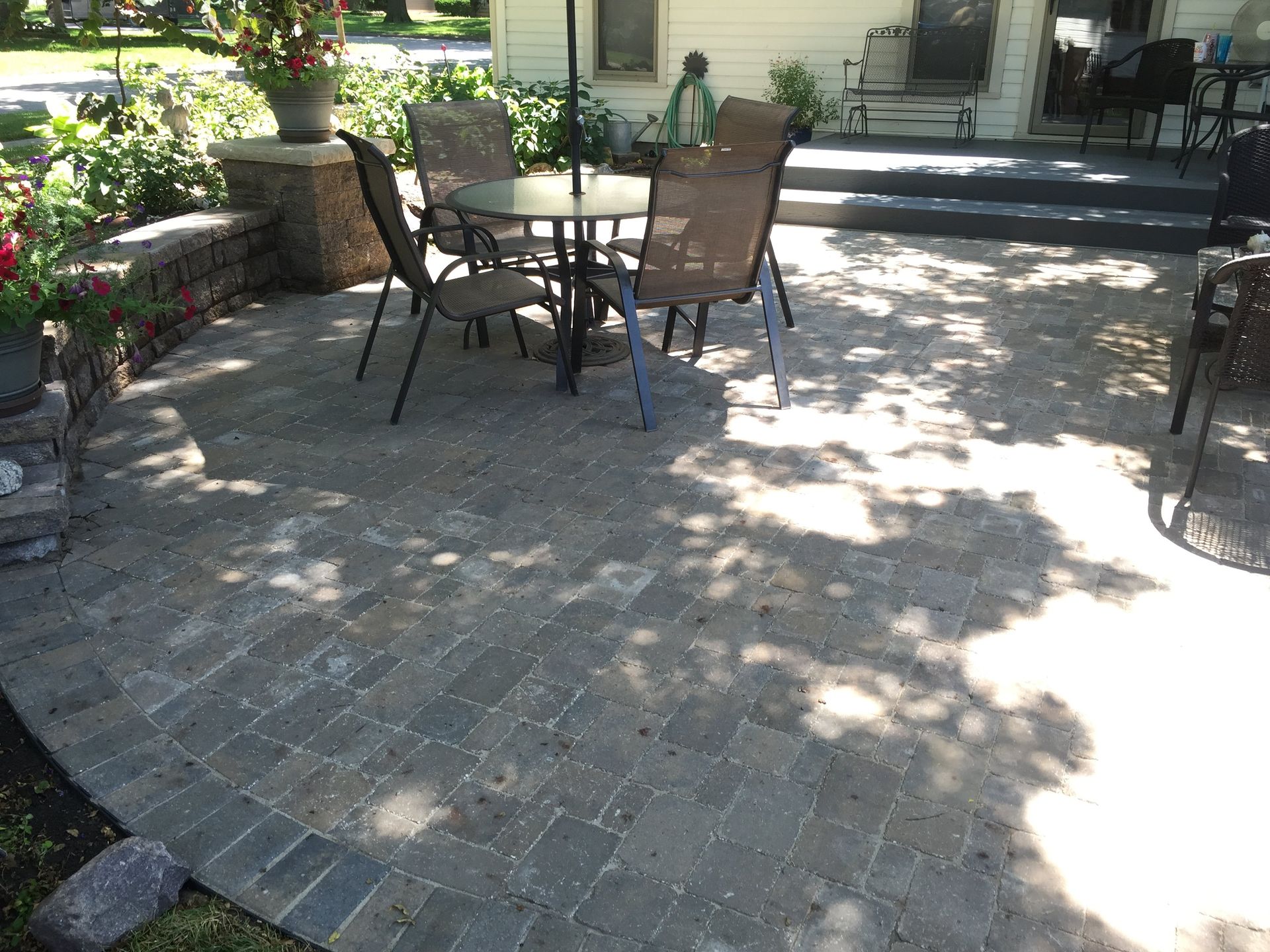 A patio with a table and chairs in front of a house.