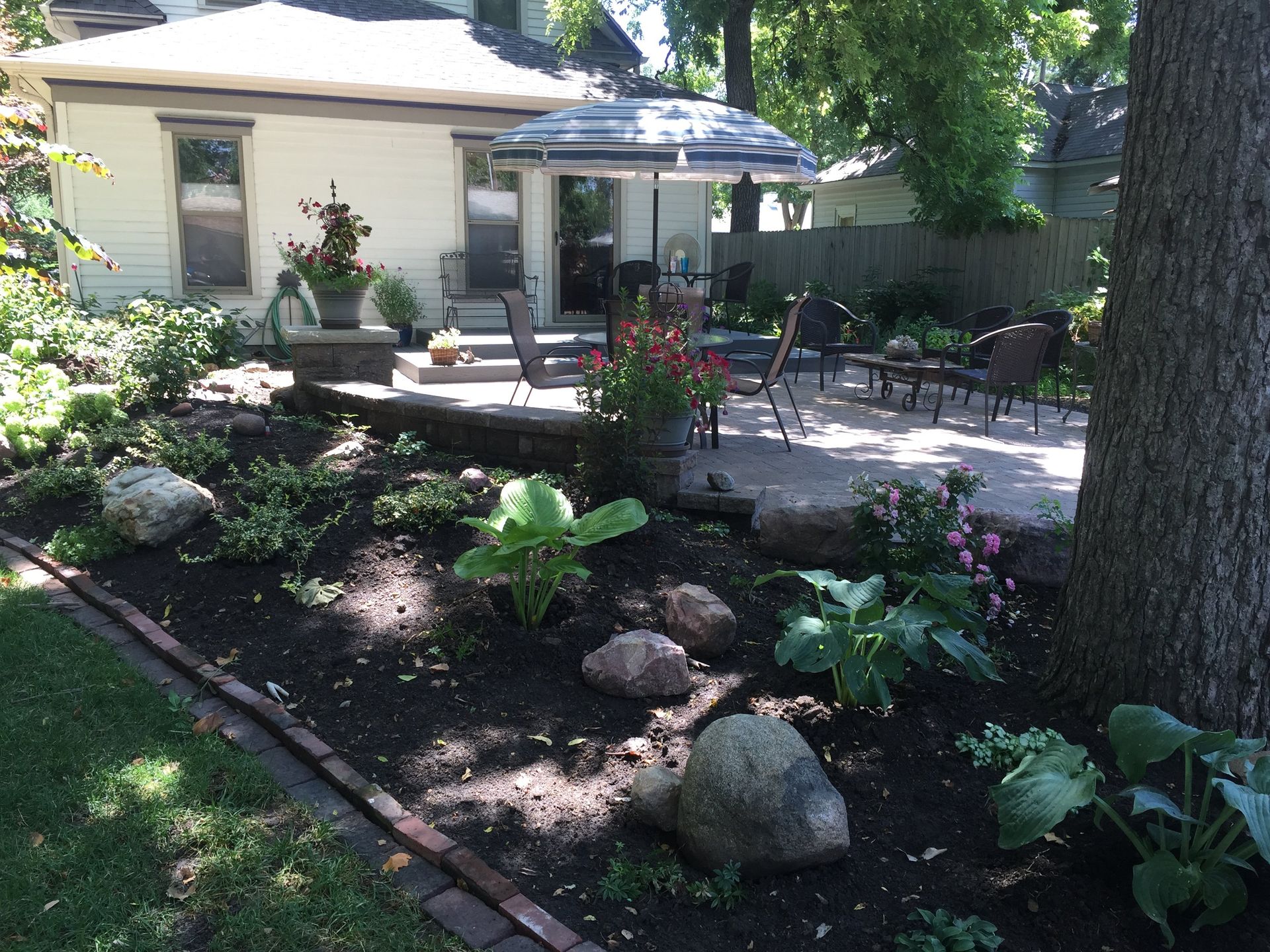 The backyard of a house with a patio and umbrella