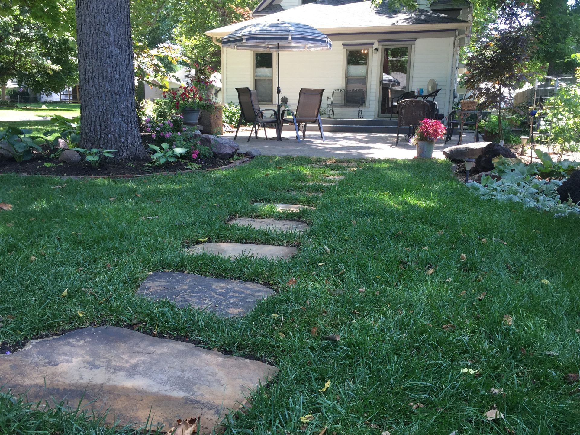 A house with a patio and umbrella in the backyard