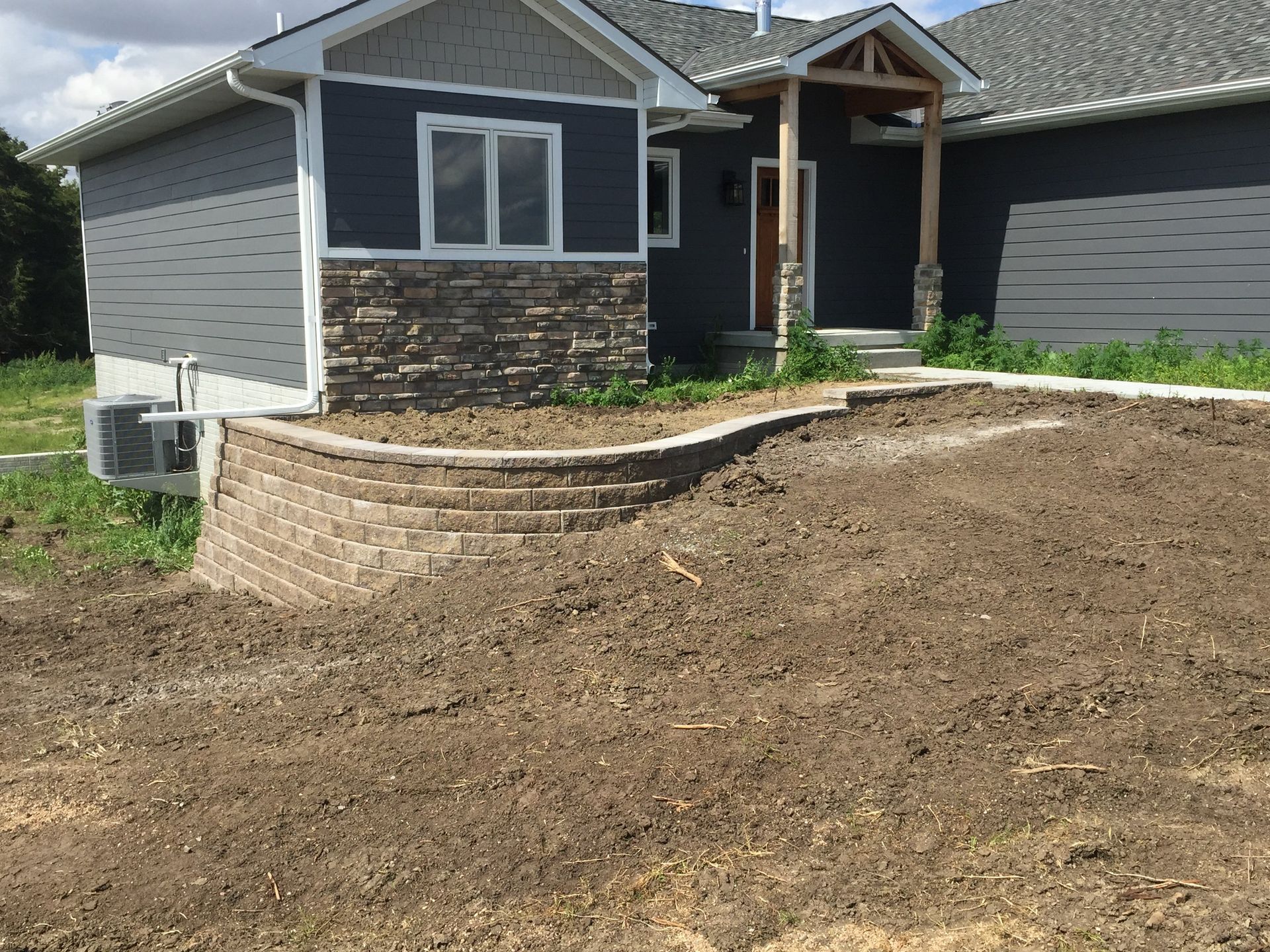 A house with a brick wall in front of it