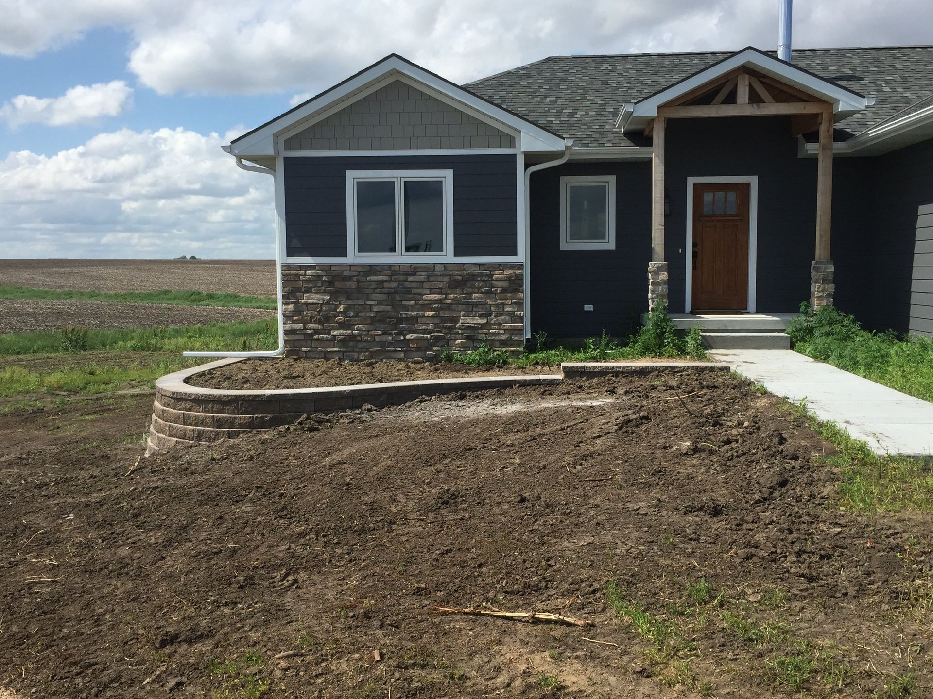 A house is sitting in the middle of a dirt field.