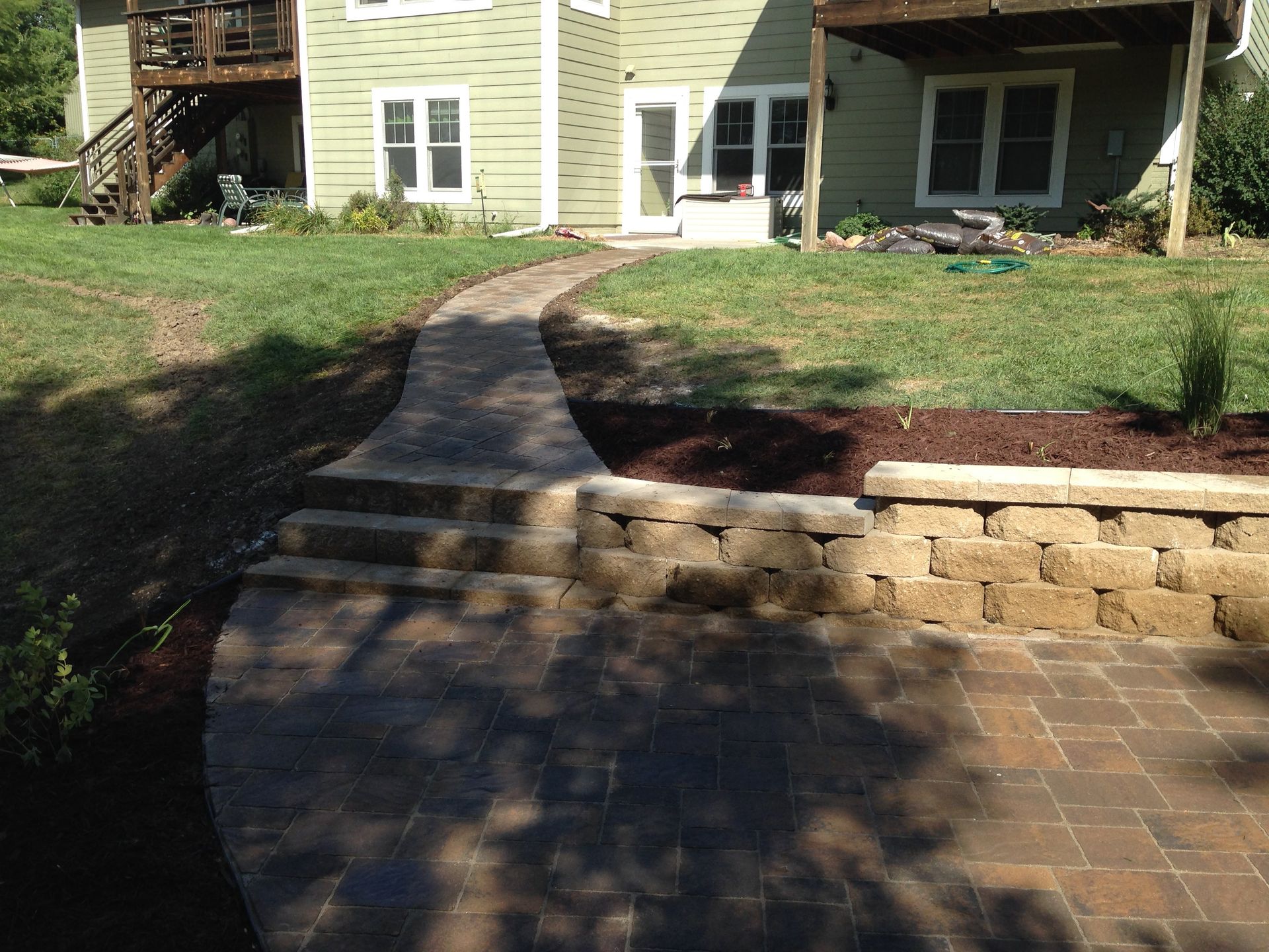 A walkway leading to a house with a patio in front of it