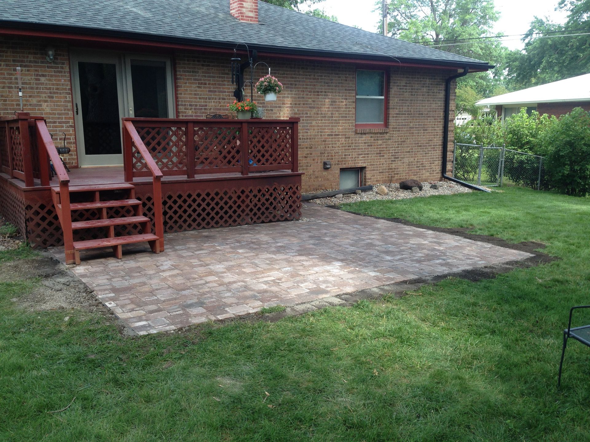 A brick house with a deck and stairs in the backyard