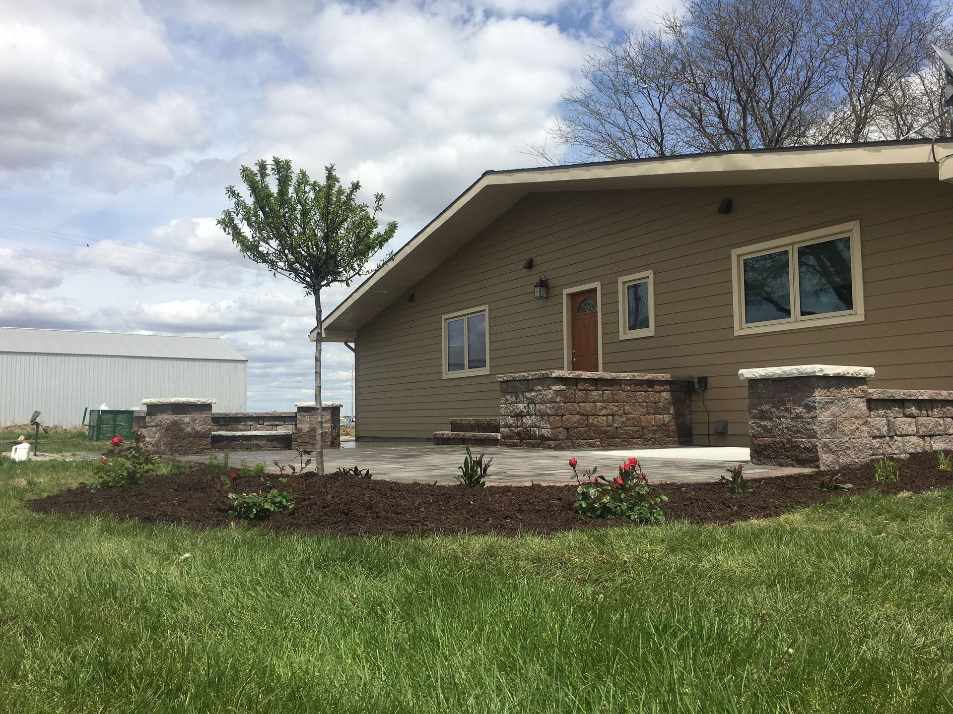 A house with a patio and a tree in front of it.
