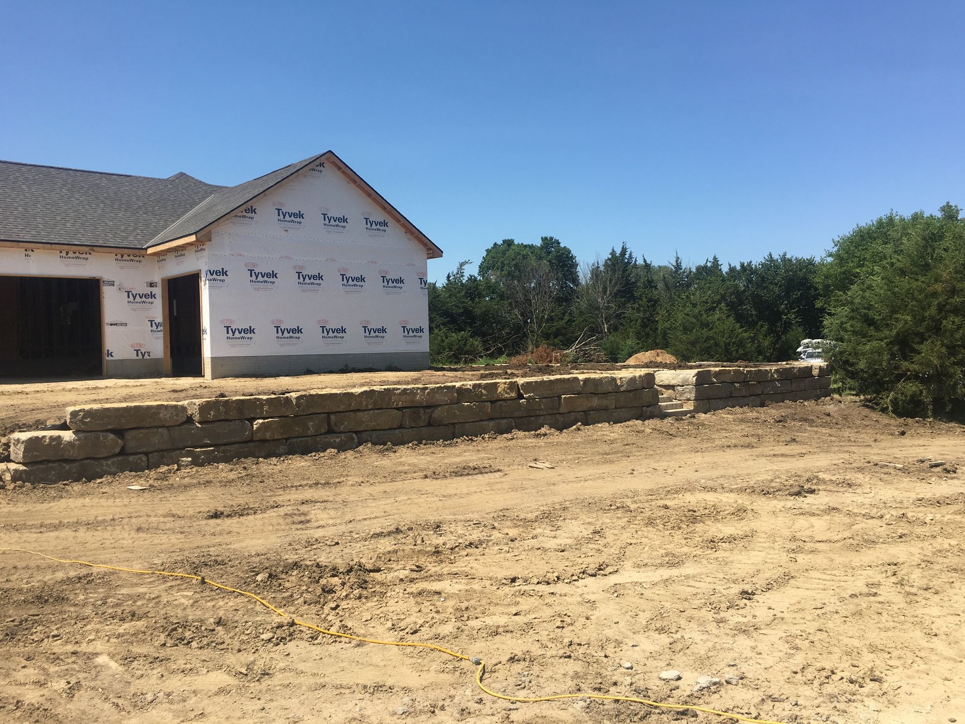 A house is being built in the middle of a dirt field.