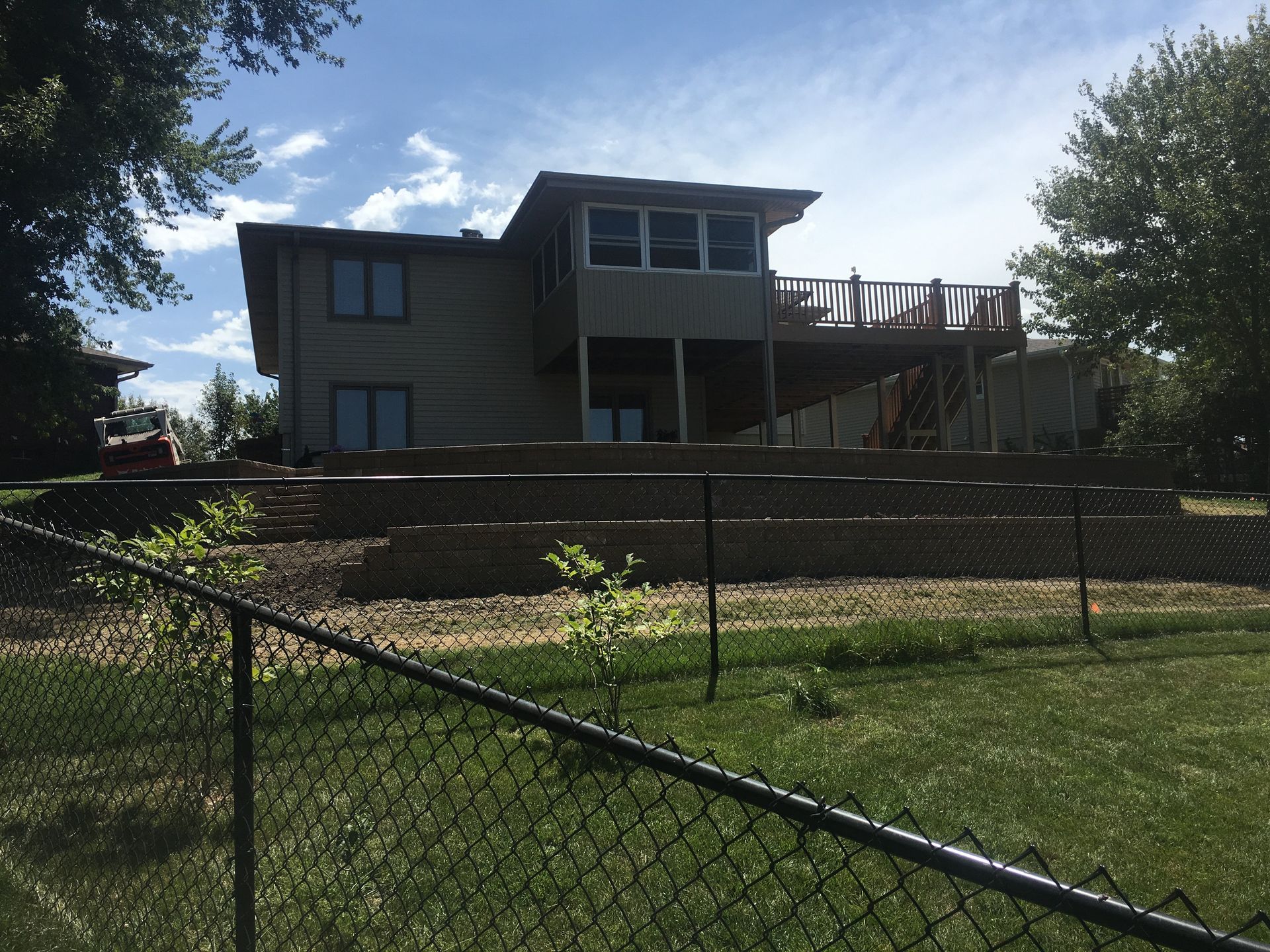 A large house is behind a chain link fence
