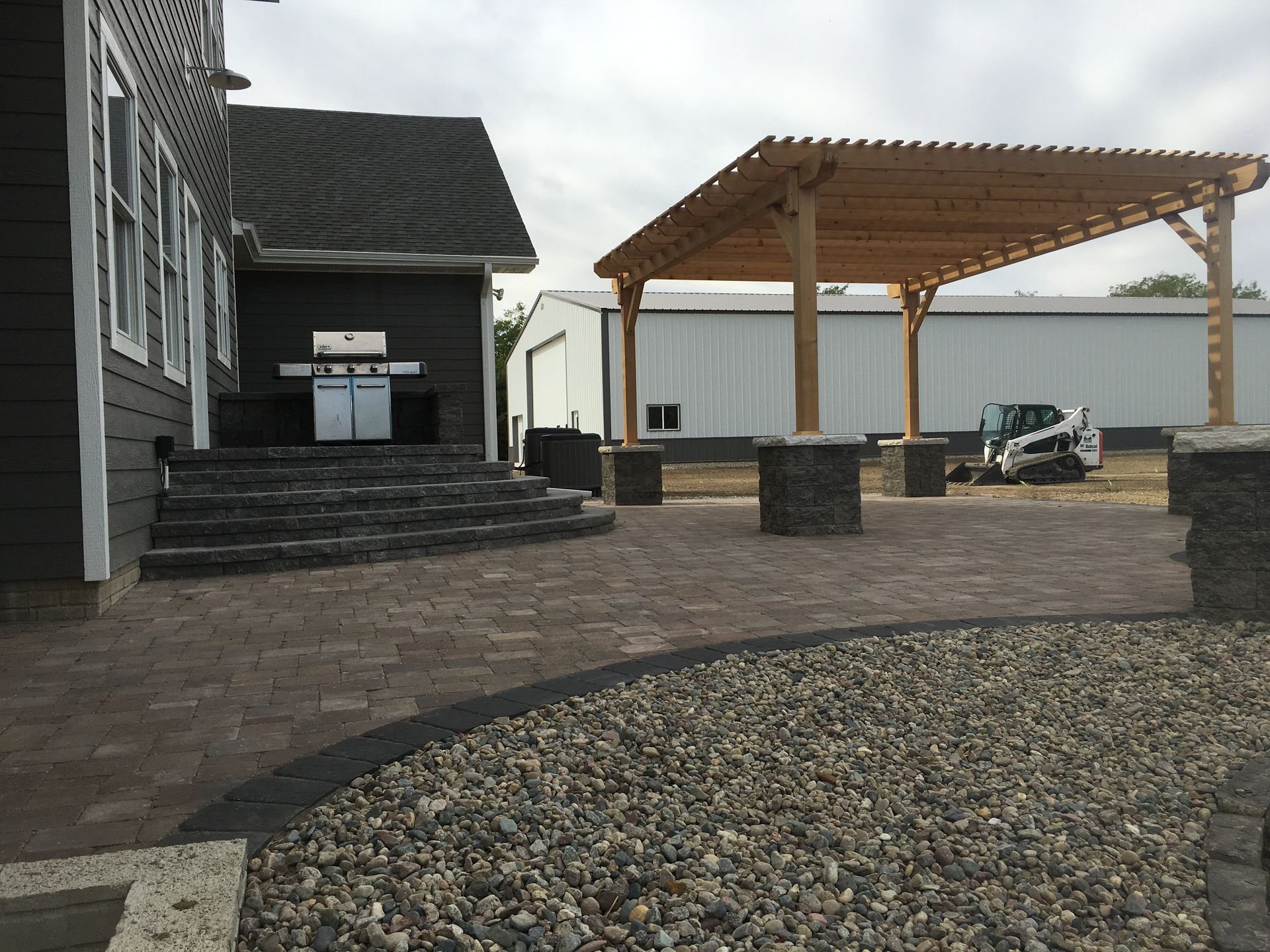 A house with a patio and a pergola in front of it.