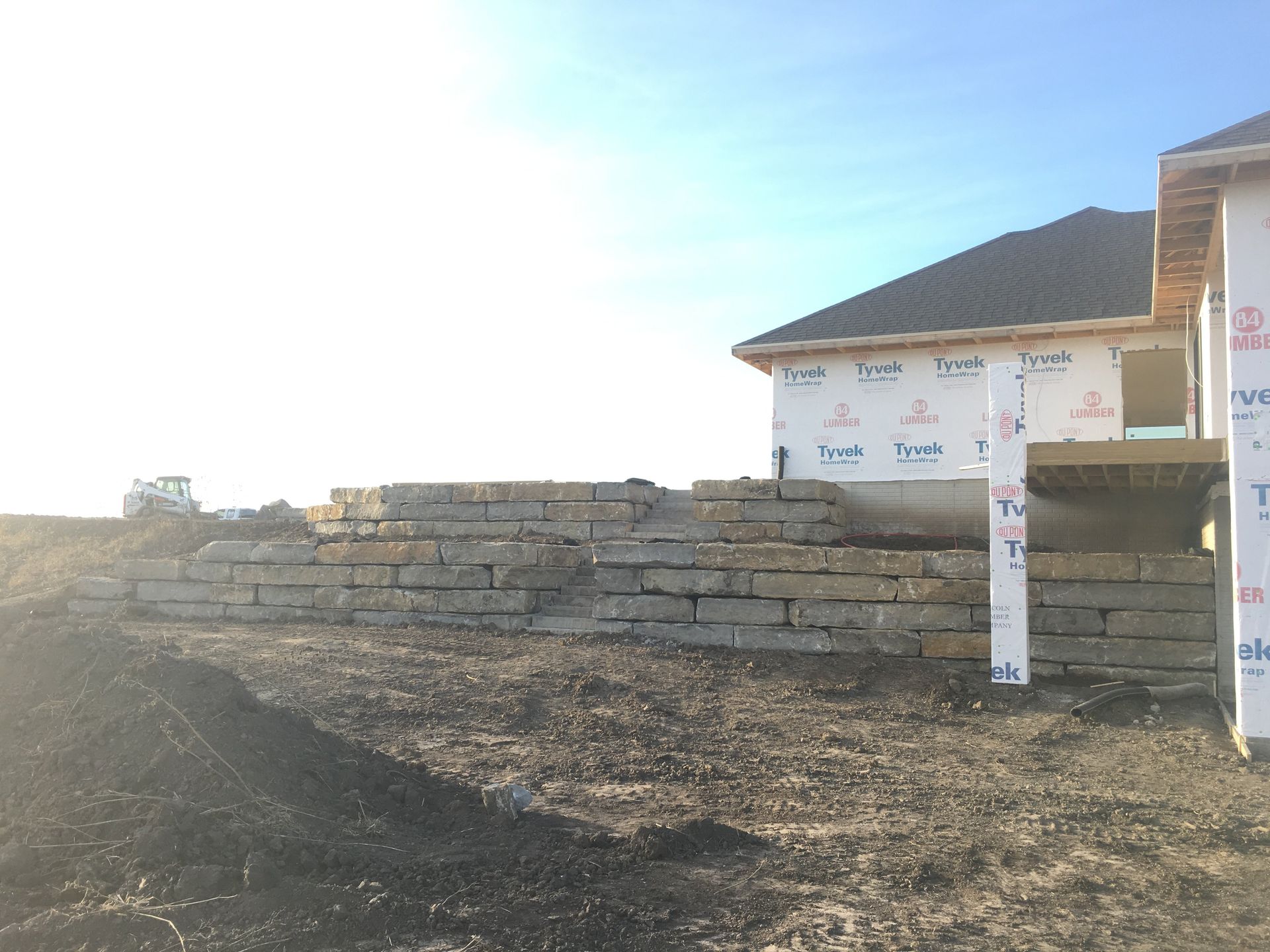 A house is being built in the middle of a dirt field.
