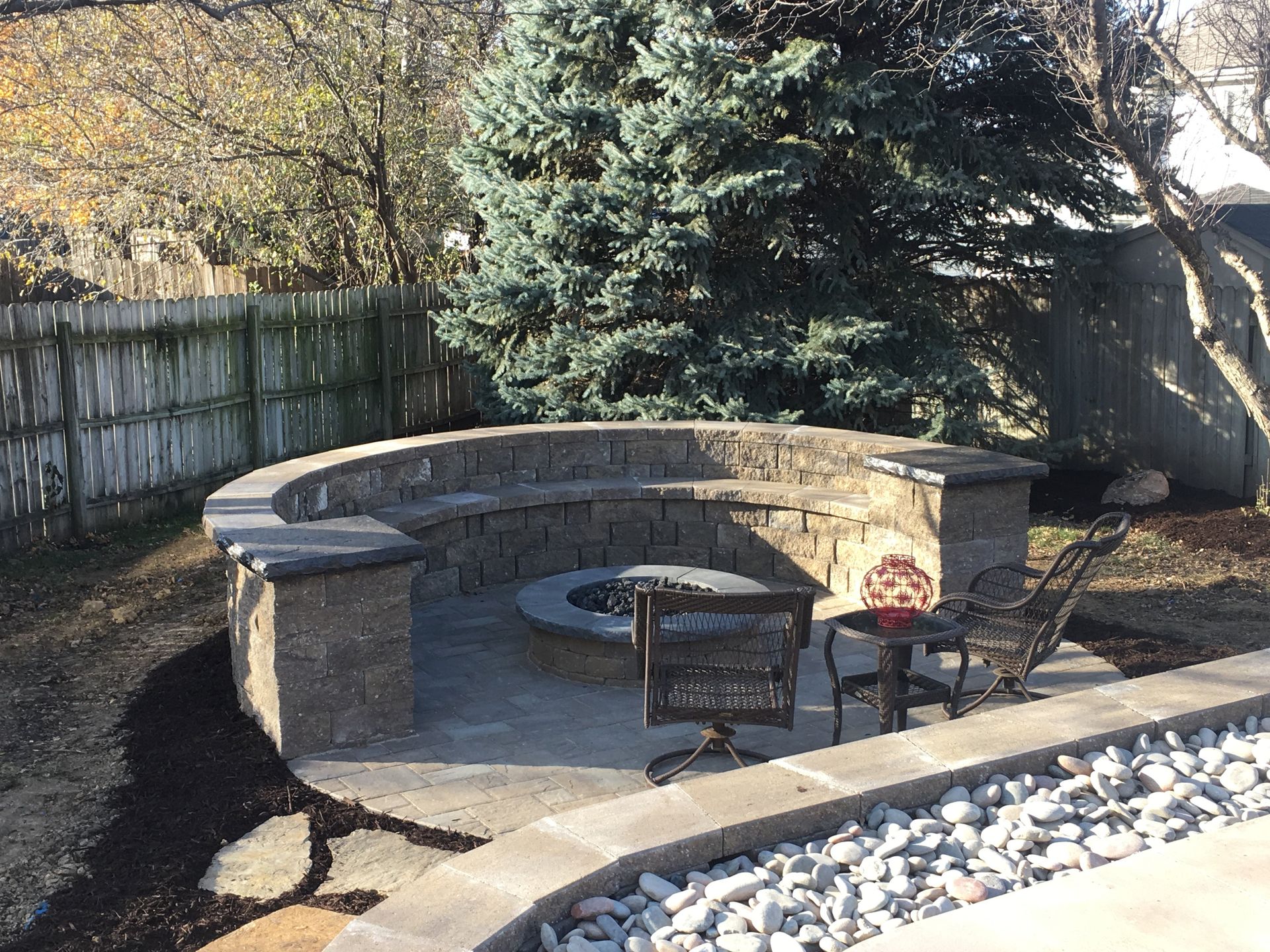 There is a fire pit in the middle of the backyard.