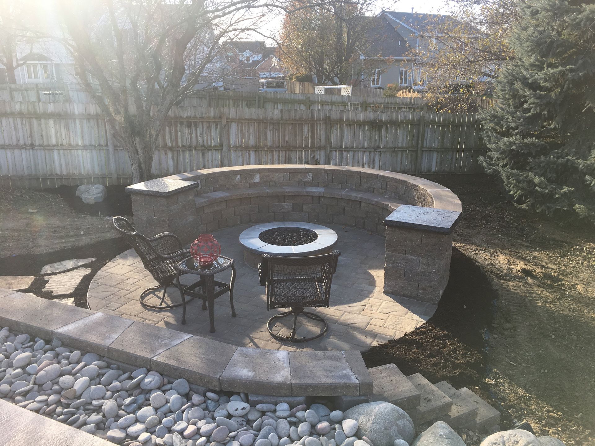 A patio with a fire pit and a table and chairs