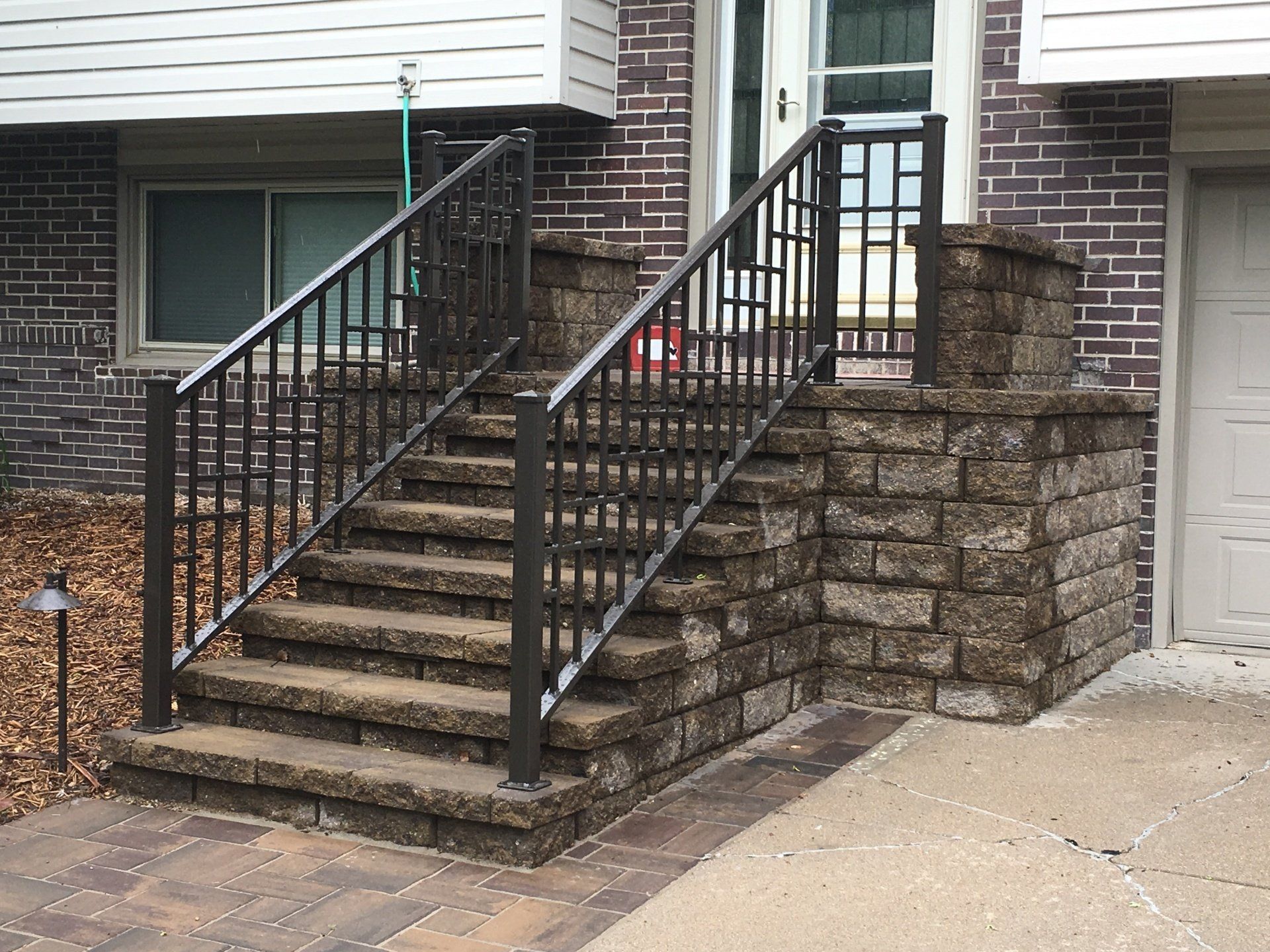 A set of stairs leading up to a house with a wrought iron railing