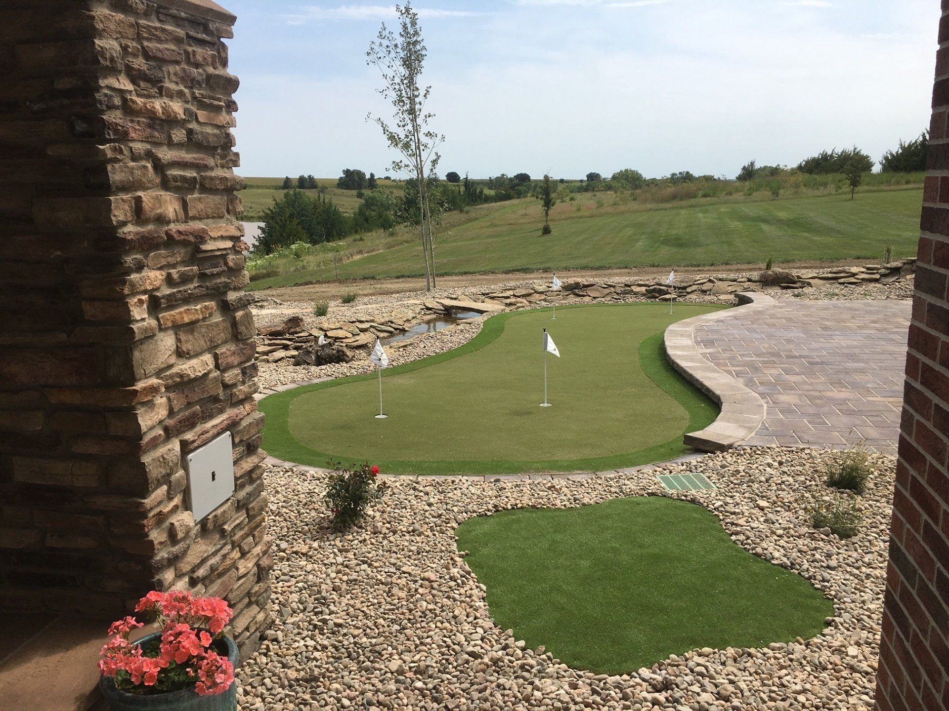 A putting green in a backyard next to a brick wall