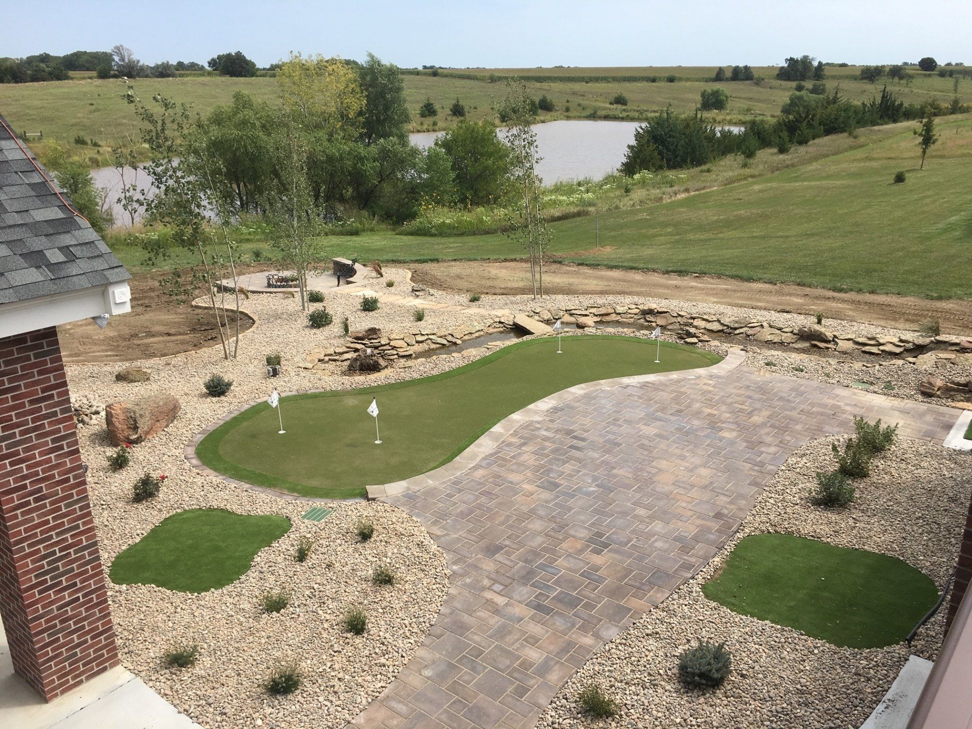 An aerial view of a golf course with a lake in the background