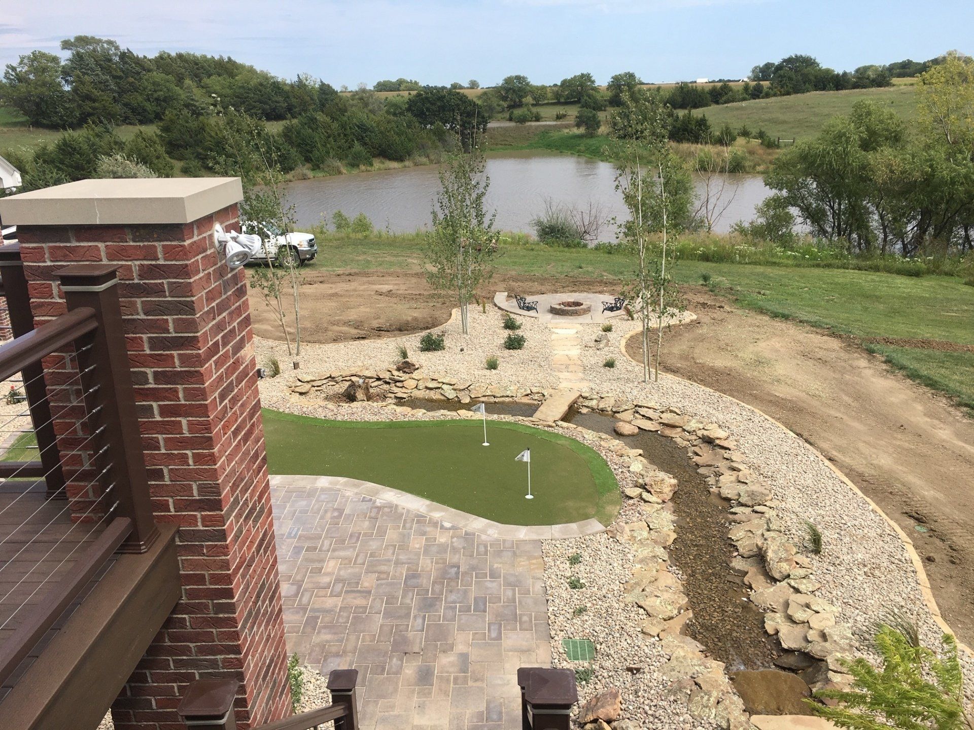 An aerial view of a backyard with a pond and a brick chimney.
