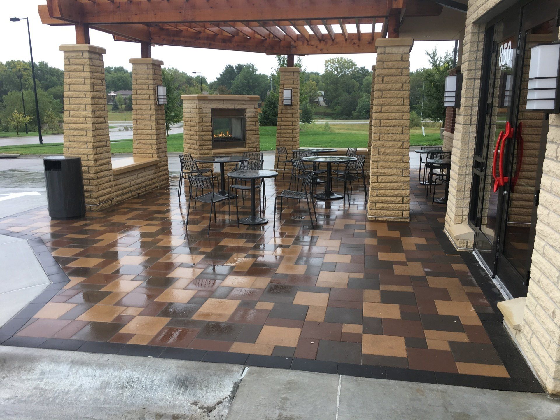 A patio with tables and chairs under a pergola