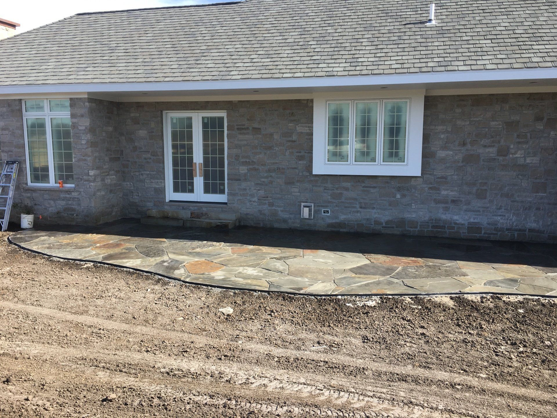 A brick house with a stone patio in front of it.